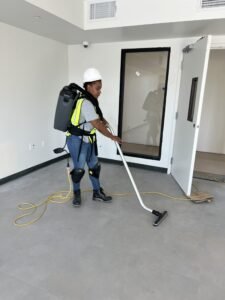 Cleaning business crew member using commercial backpack vacuum during a post-construction cleaning job