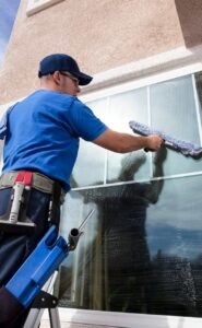 Cleaning business owner washing a commercial storefront window